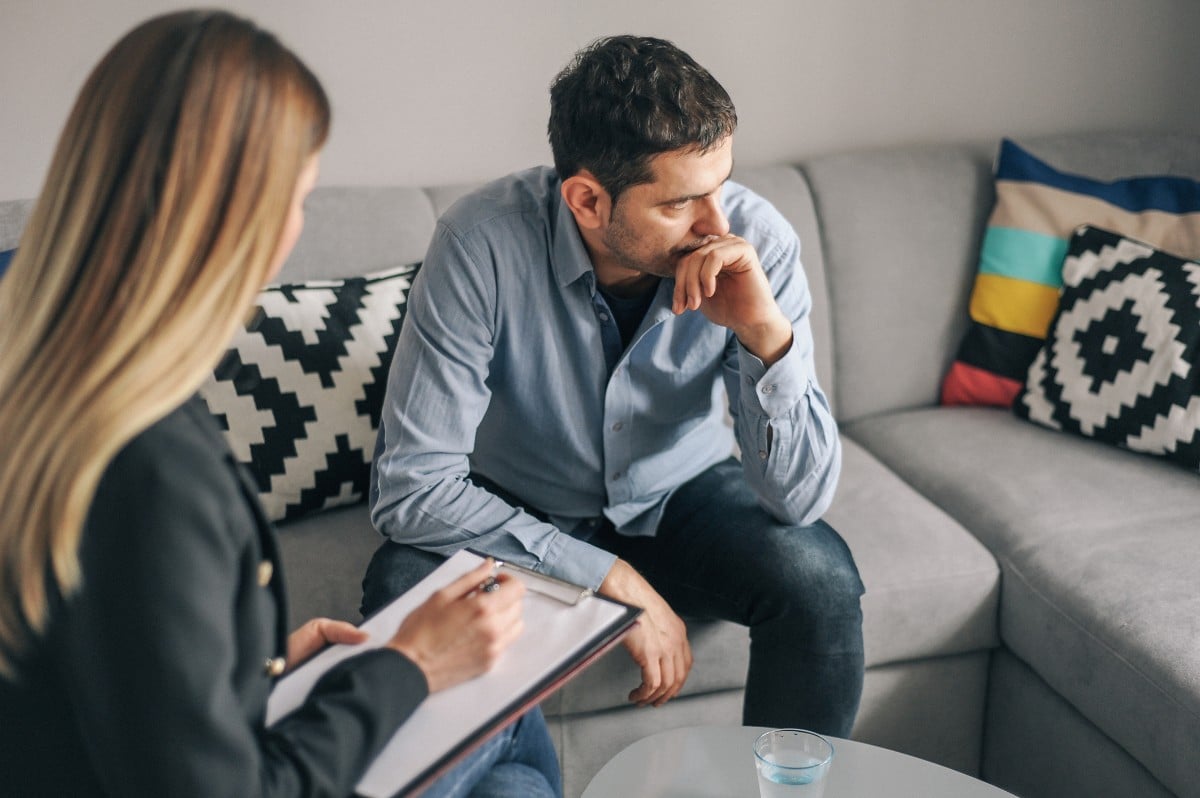 An adult man looking apprehensive during an exposure therapy session in Naperville