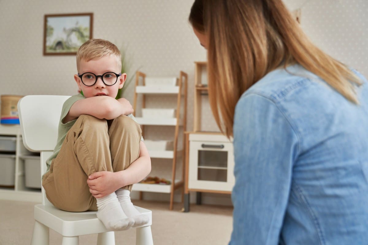 A boy with ADHD looking away from his therapist during therapy in Naperville